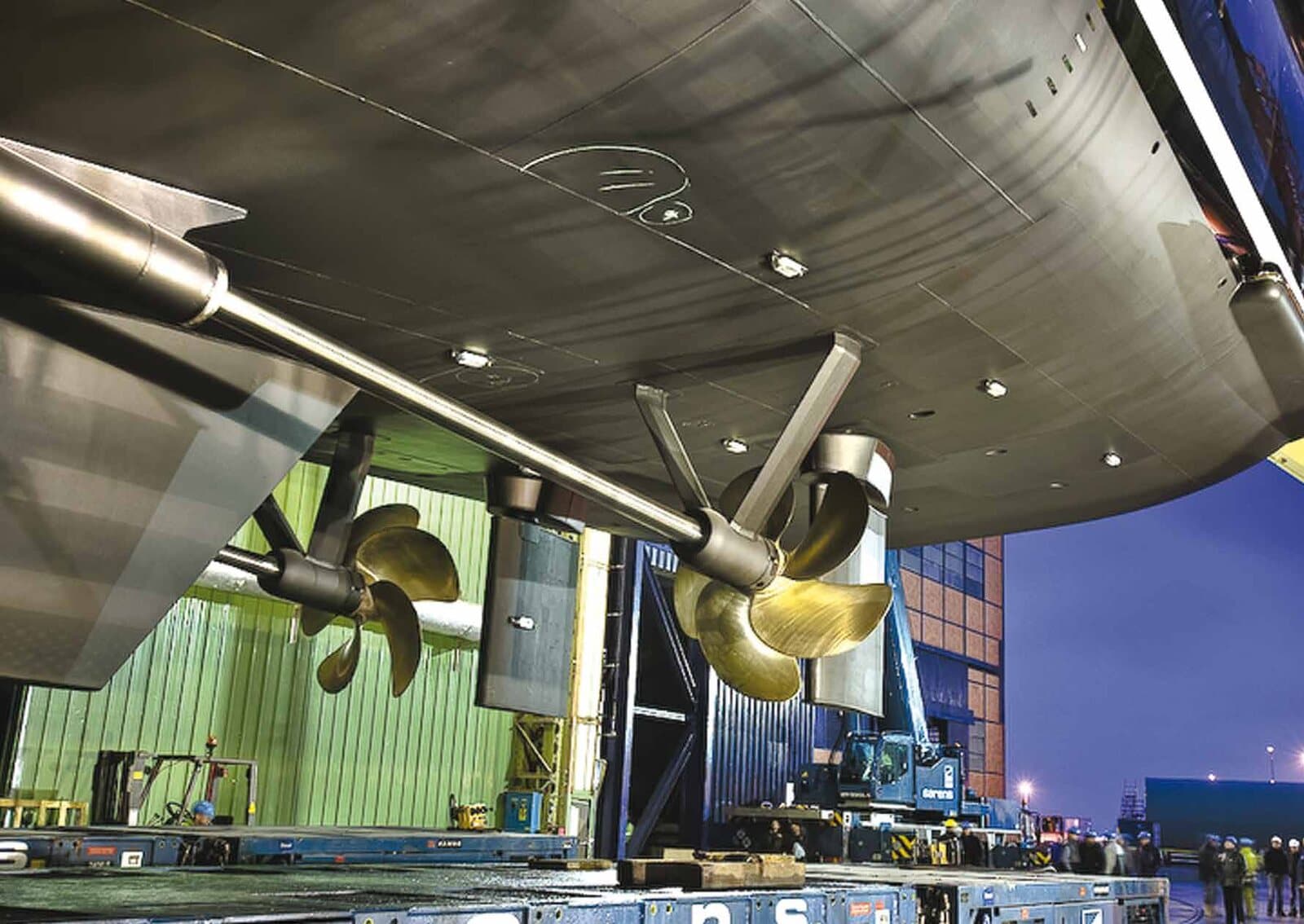 Large twin propellers under a ship's hull in drydock